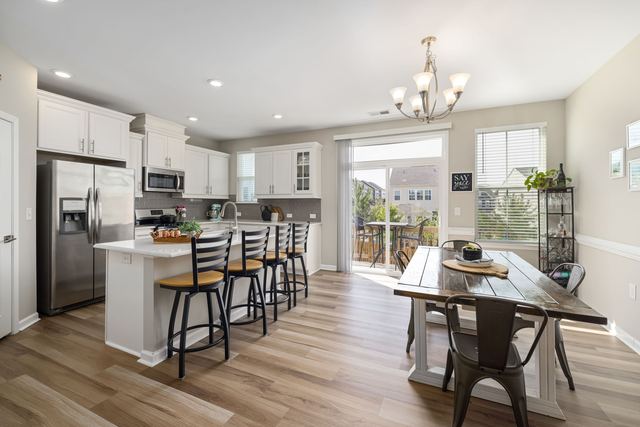 Coin repas avec banquette dans une cuisine Table en bois et banquette d'angle installées sous la fenêtre d'une cuisine