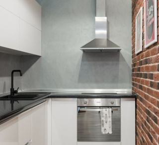 Coffrage en bois clair enveloppant une hotte au-dessus d'une plaque de cuisson